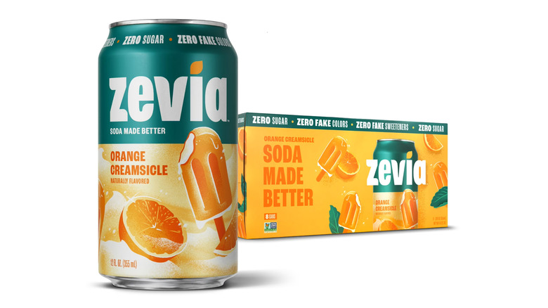 An eight-pack of Zevia Orange Creamsicle soda sits against a white background, with a can of the drink prominent in the foreground