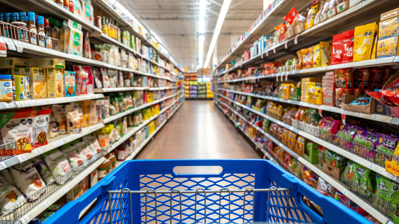 The front of a shopping cart is visible in a Walmart shopping aisle