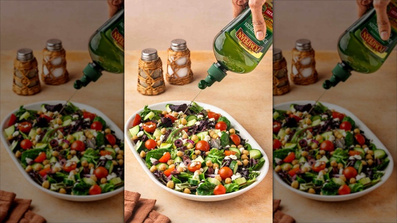 Someone squeezes Pompeian olive oil onto a salad from the newly designed bottle