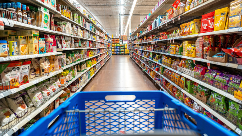 A Walmart cart stands at the beginning of an aisle