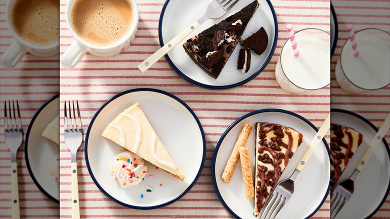 Freshness Guaranteed cheesecake slices on plates on a striped tablecloth