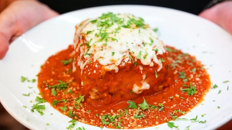 Plate of Gaetano's famous lasagna with melted cheese and fresh herbs