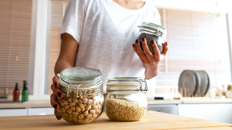 A home baker picks up glass jars containing dry goods