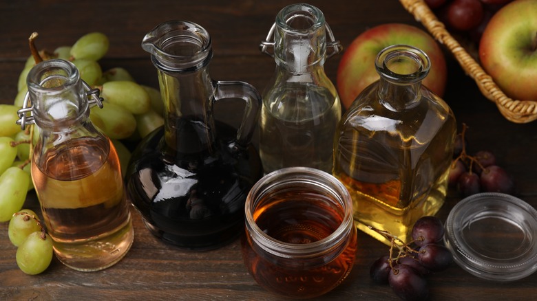 A variety of vinegars and fresh fruits on a table