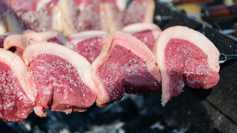 Picanha steak spitted over hot charcoal