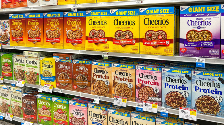Various boxes of Cheerios on shelves.