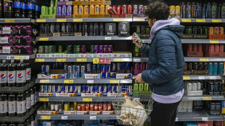 Person browsing energy drinks at store.