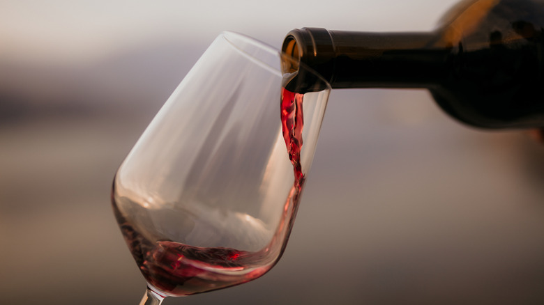 A glass of red wine being poured.