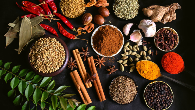 ground and whole spices on a black background