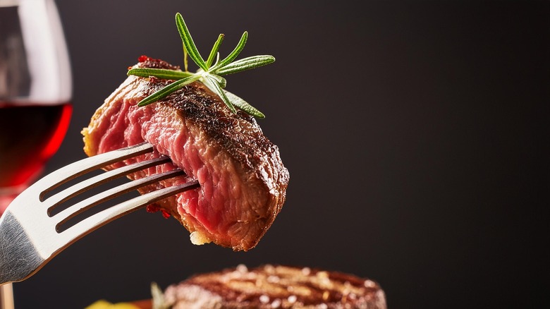 sliced piece of steak with garnish on a fork