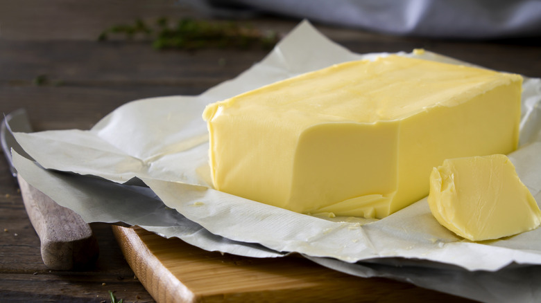Block of butter on paper on a cutting board