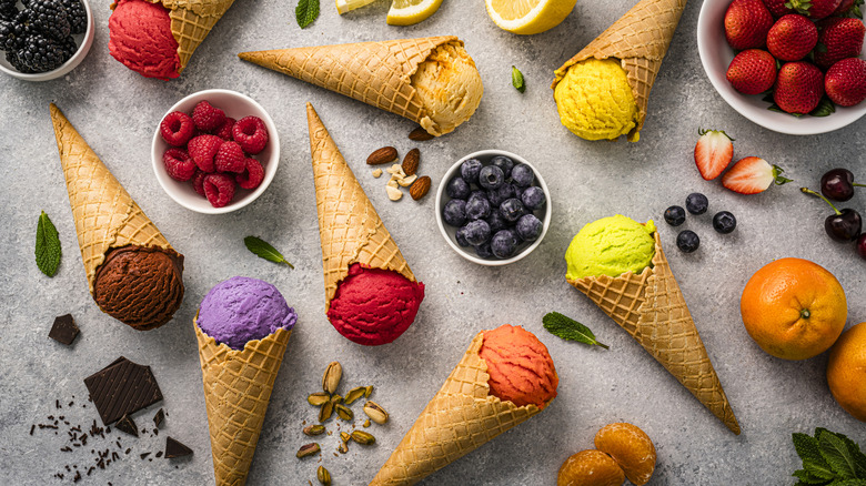 Different ice creams and fruits on a table.
