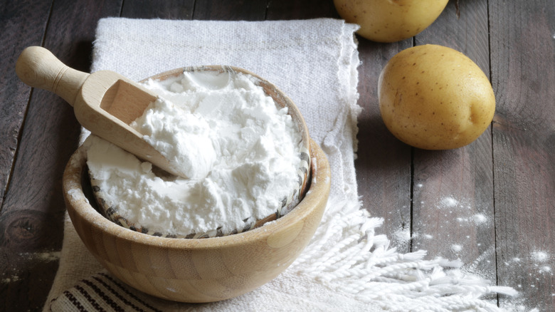 bowl of potato starch displayed alongside spuds
