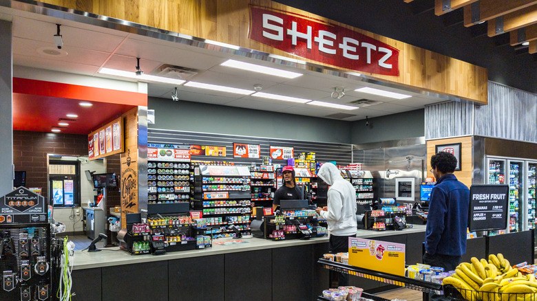 Customers stand in line at a Sheetz checkout counter.