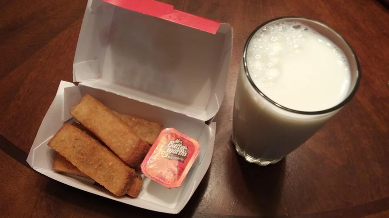 French Toast Sticks from Sheetz next to a glass of milk.