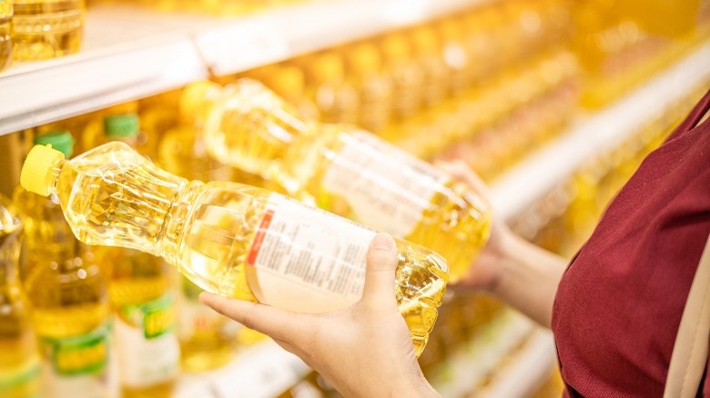 Woman holding bottles of vegetable oil