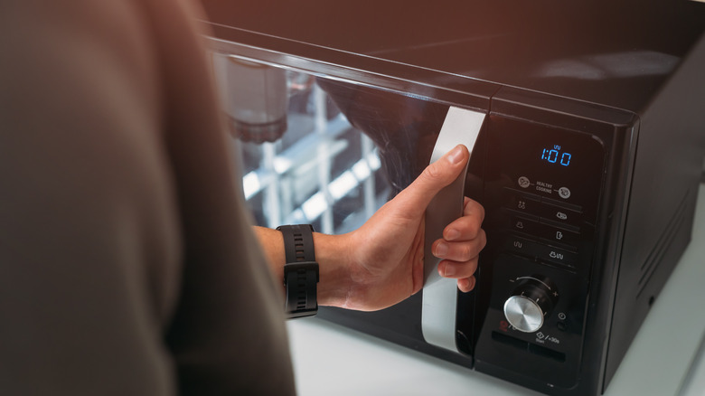 Man using a microwave in a kitchen