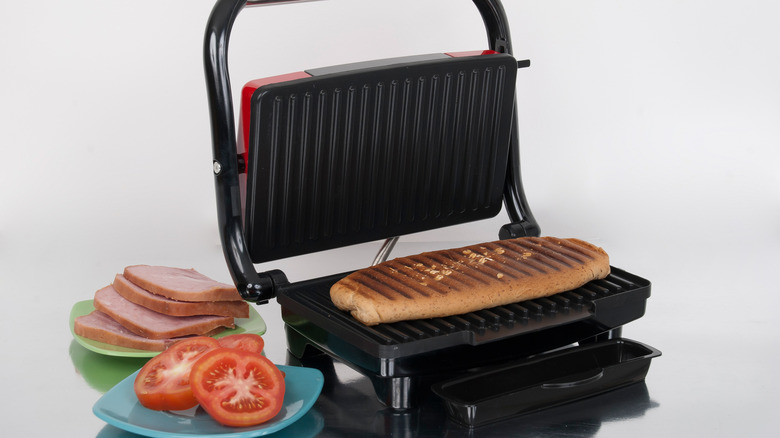 panini press with sandwich and fillings on display