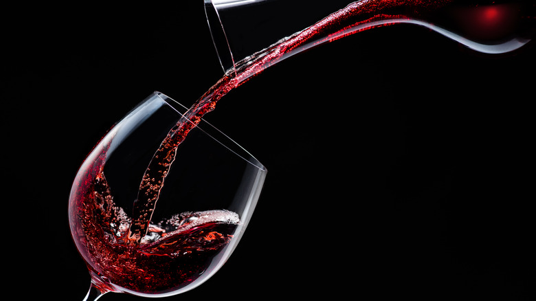 Red wine pouring from decanter into glass