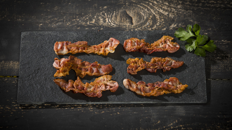 Bacon on a black slate background.