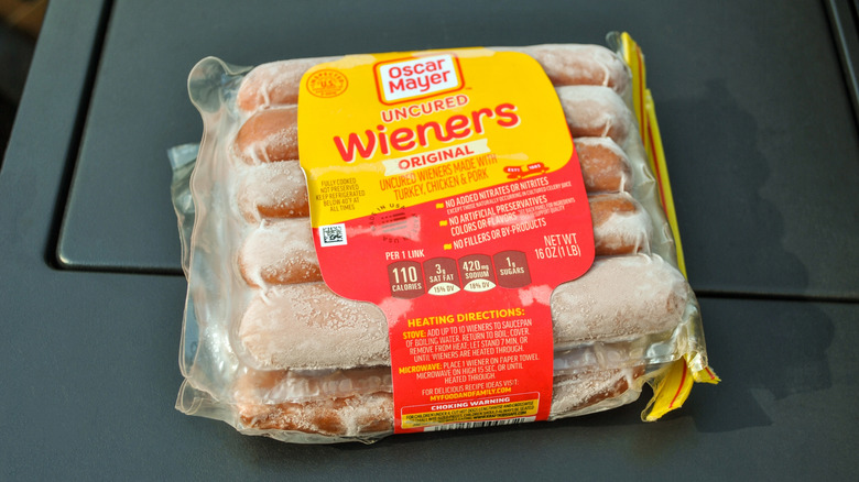 A package of Oscar Meyer wieners sits frozen on a black surface