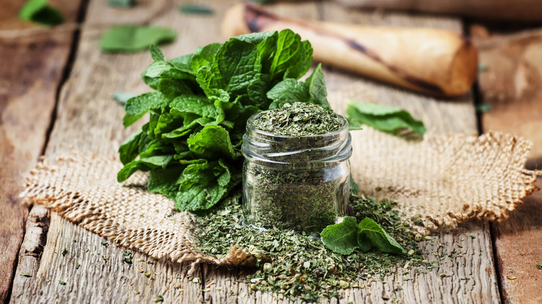 mint leaves next to jar of ground dried mint