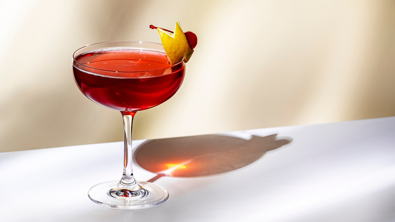 A cosmo garnished with lemon and a cherry.
