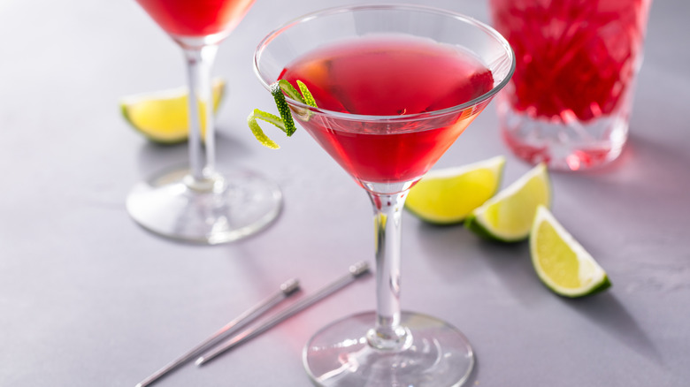 A cosmo garnished with a twist of lime.