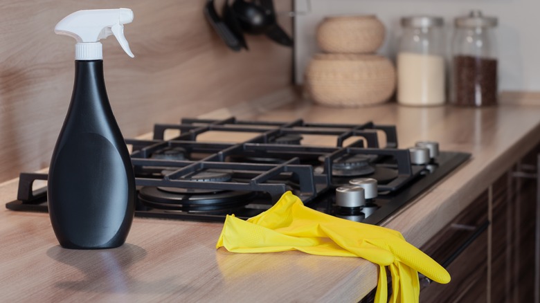 Rubber gloves and spray bottle on stovetop