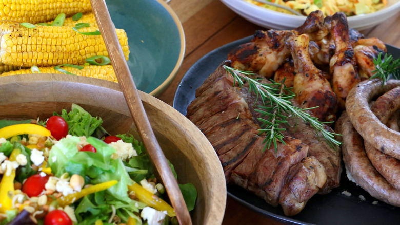 grilled meats, corn, and salad