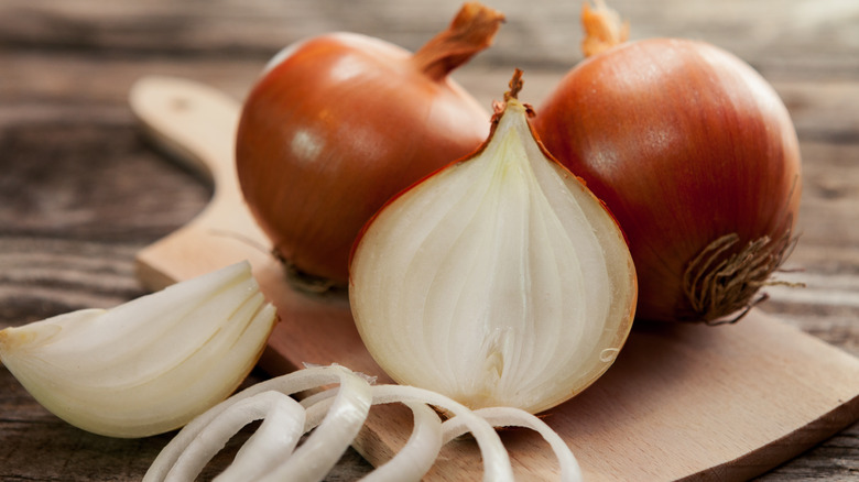 An onion half next to whole onions