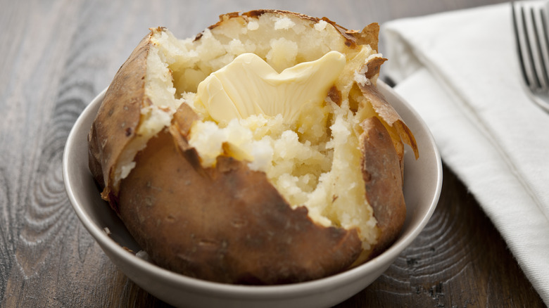 Buttery baked potato in bowl