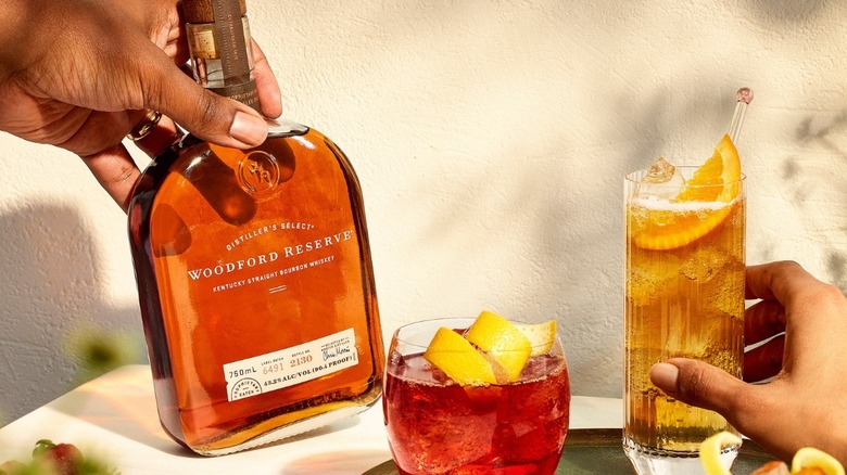 woodford reserve bourbon and hands and cocktail