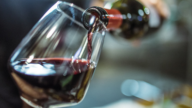 pouring red wine in glass
