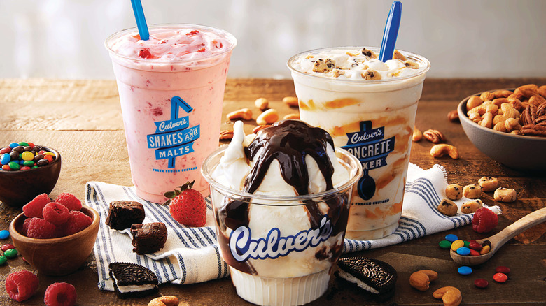 A Culver's shake, sundae, and Concrete Mixer sit near containers of various toppings