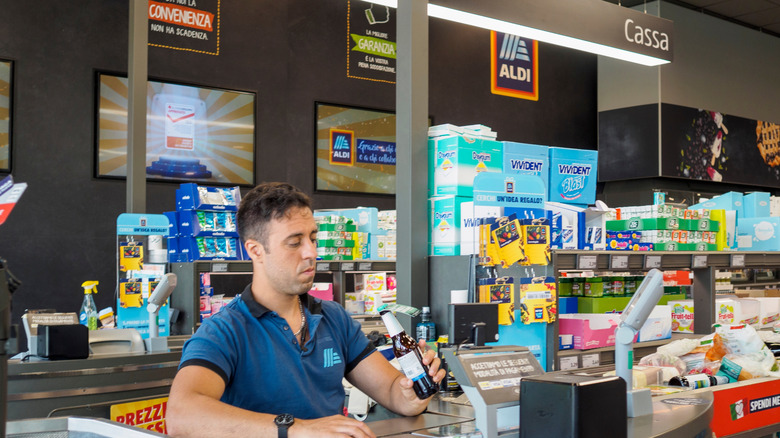 checkout guy from Aldi gazing at a beer
