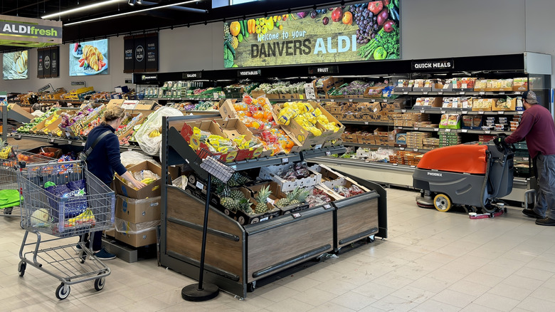 An Aldi produce section with people in it