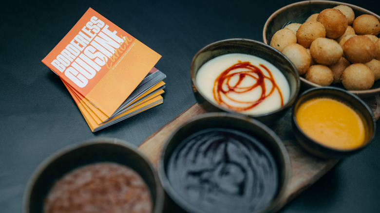 Borderless cuisine menus next to a variety of sauces
