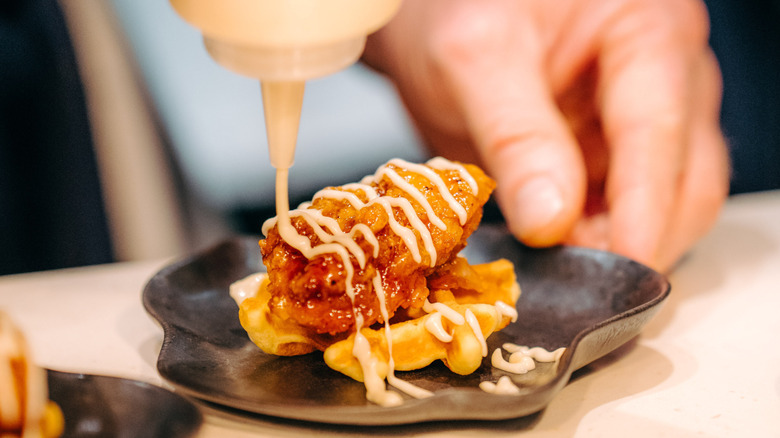 Creamy sauce drizzled on chicken and waffles