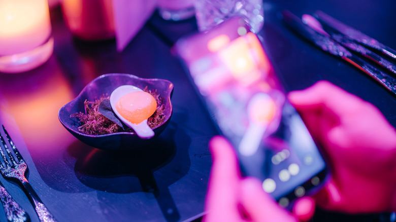 A phone taking a photo of food on a spoon