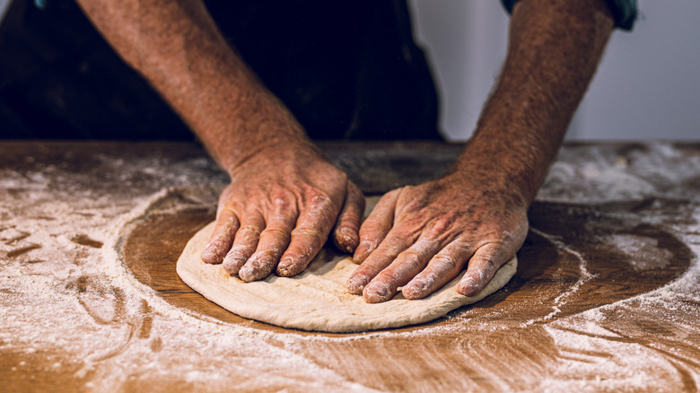 Hands kneading pizza dough  