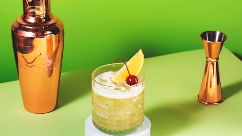 Classic whiskey sour next to shaker