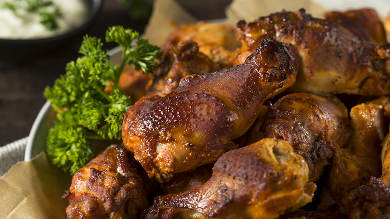 Smoked chicken wings served on a platter with fresh herbs