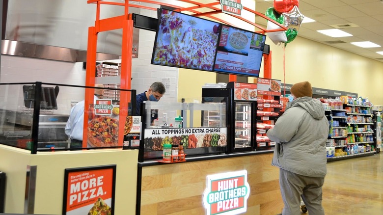 A customer waits for their pizza at a Hunt Brothers Pizza stand located at Tinker Air Force Base