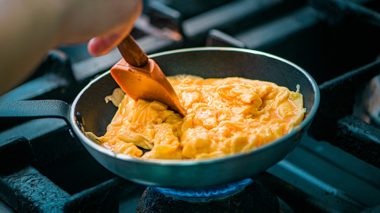 Cooking scrambled eggs in a pan on the stove