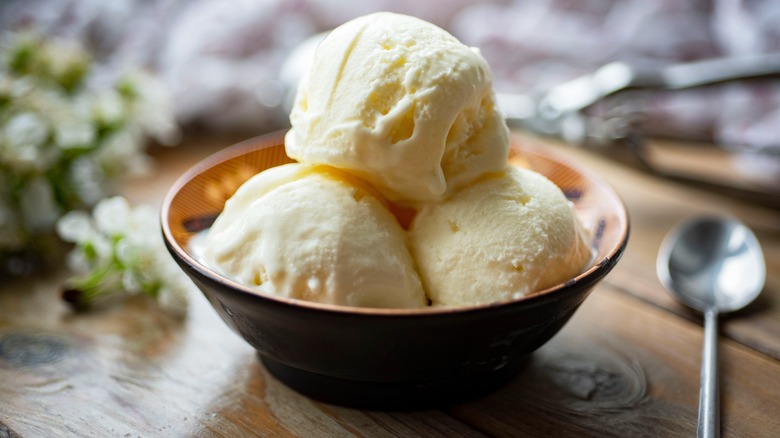 Three scoops of creamy vanilla ice cream in bowl