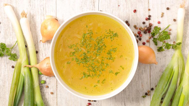 bowl of chicken broth with herbs