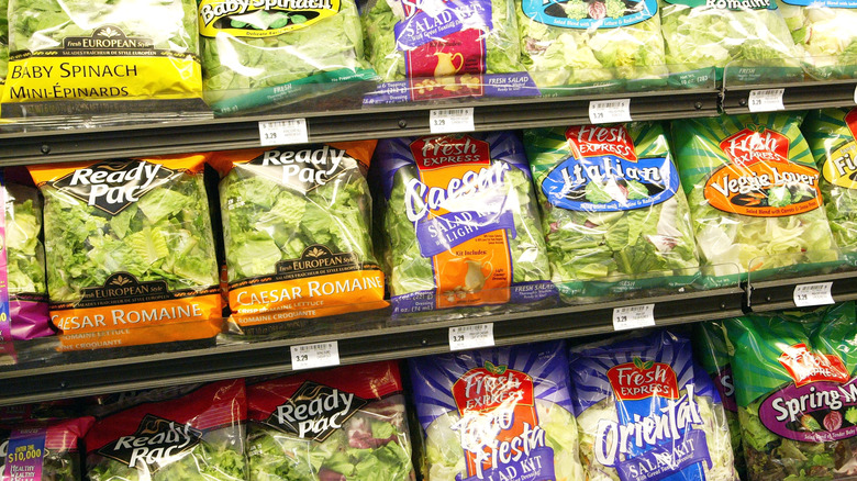rows of bagged salad available for sale at a grocery store