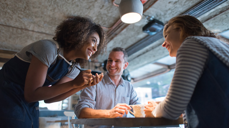 Server taking order from 2 people at restaurant table