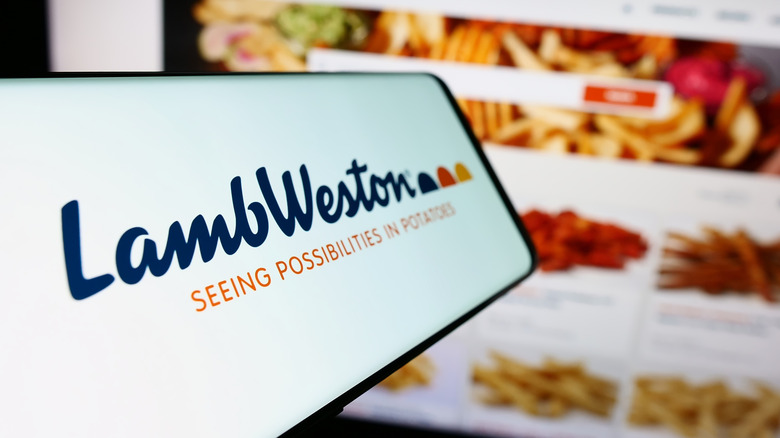 Phone with the Lamb Weston logo, behind it their website displaying products